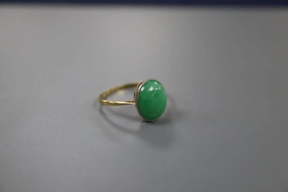 An 18ct and oval cabochon jade set ring, size Q, gross 2.8 grams.